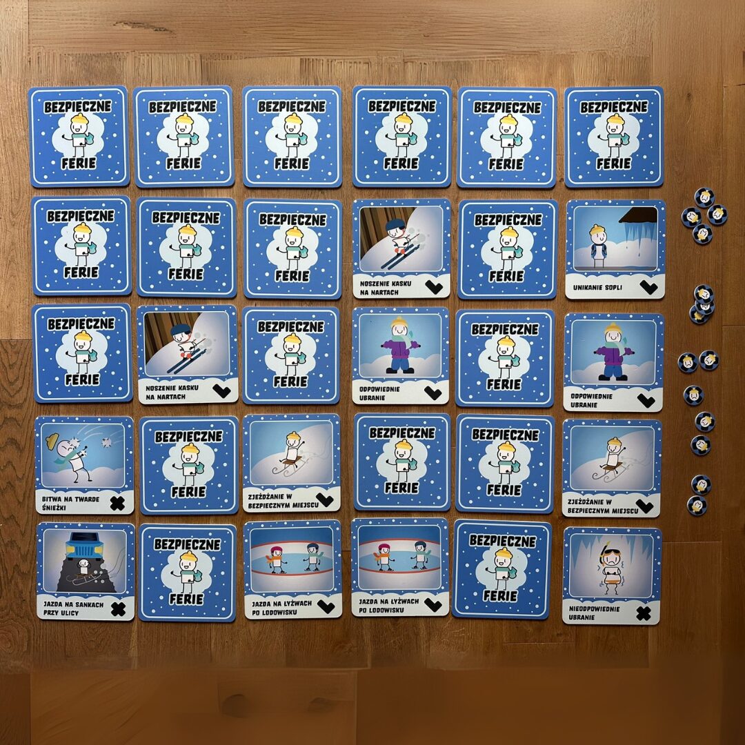 Karty edukacyjne z gry „Bezpieczne Ferie” uczące zasad zimowego bezpieczeństwa, m.in. noszenia kasku na nartach i odpowiedniego ubioru